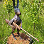 Metal hare sculpture nestled in long grass