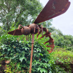 Rusty metal hornet sculpture on pole
