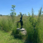 Hare sculpture with gun on tree stump stalking