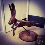 Leaping metal hare sculpture indoors