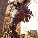 Forward facing metal horse head sculpture in woods