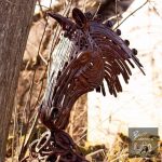 Forward facing metal horse head sculpture in woods