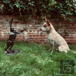 Hare with gun sculpture posed with dog