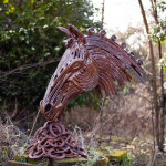Metal horseshoe sculpture eating pile of hay