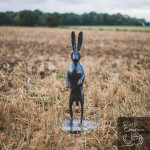 Front on hare sculpture on stubble field