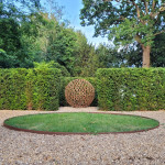 Sculpture in landscaped garden made from metal horseshoes