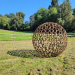 Rusty horseshoe sculpture sitting on the edge of the paddock