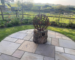 Horseshoe sphere sculpture on patio in garden