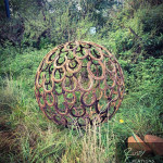 Rusty metal horseshoe sphere in the undergrowth