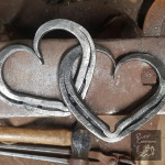 Interlocked metal hearts on anvil