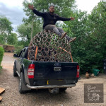 Sphere sculpture loaded on truck with William Moulton-Day posing on it