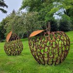 metal apple and pear sculptures on grass lawn