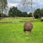 Metal sculpture sitting in the paddock on tree stump plinth