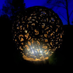 Misfit sphere sculpture lit up at night